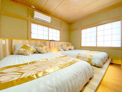 two beds in a room with two windows at YOUAN - Vacation STAY 36473v in Oishi