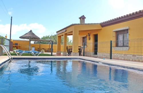 a swimming pool in front of a house at Casa Calas Boliña in Roche