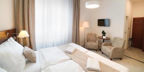 una camera d'albergo con letto e sedia di Hotel KOZÁK a Brno