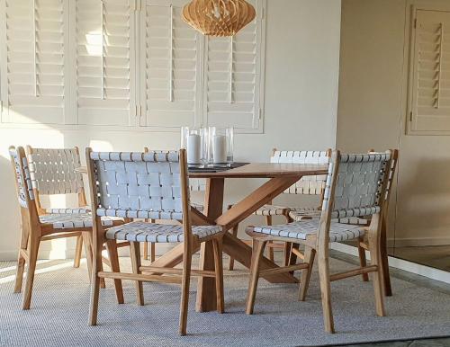 uma mesa de jantar com 2 cadeiras e uma mesa e cadeiras de madeira em Mooloomba Two em Point Lookout