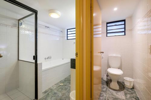 uma casa de banho com um WC e uma banheira em Mooloomba Two em Point Lookout
