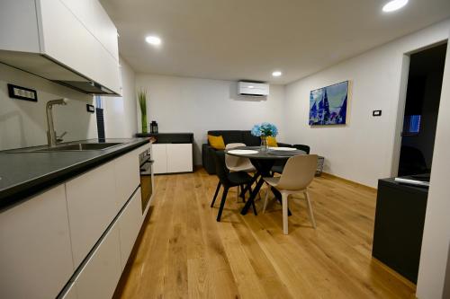 uma cozinha e sala de estar com mesa e cadeiras em Poseidon Apartment em Izola