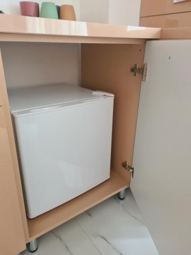 einen weißen Kühlschrank unter einer Theke in einer Küche in der Unterkunft B&S Boutique Studio in Mamaia Nord – Năvodari