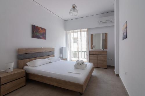 a bedroom with a large white bed and a window at Renovated Apartment next to Panathenaic Stadium in Athens