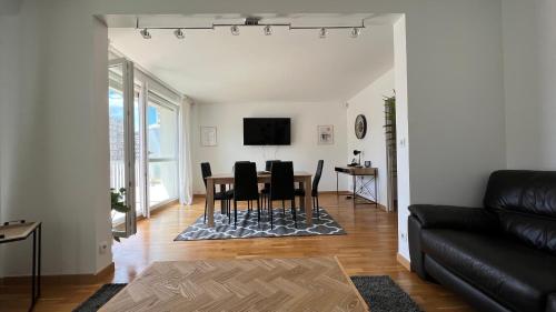 uma sala de estar com mesa e cadeiras em Superbe appartement en centre-ville, 20min de Paris, 5 min d'Enghien em Saint-Gratien