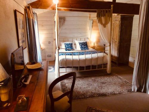 a bedroom with a bed and a chair in a room at Domaine de l’Escuderia in Parentis-en-Born