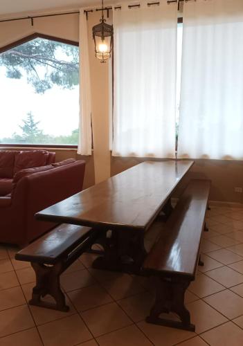 a wooden table and bench in a living room at Villa Roccia Scura dell'Etna in Zafferana Etnea