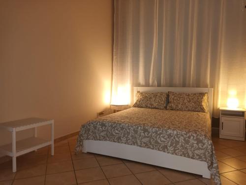 a bedroom with a bed with two lamps on it at Villa Roccia Scura dell'Etna in Zafferana Etnea