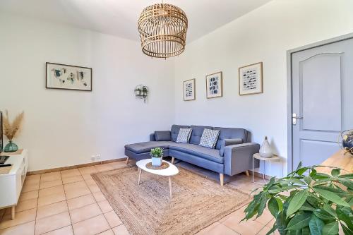 uma sala de estar com um sofá azul e uma mesa em LE REGORDANE - Appartement 4 personnes - Centre WiFi Cosy em Saint-Gilles