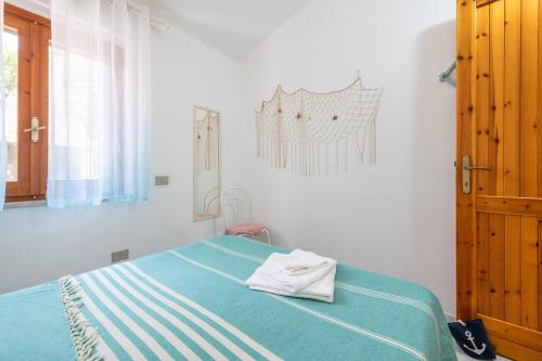 sypialnia z łóżkiem z niebieskim kocem w obiekcie La Casa di Silvia w mieście Costa Rei