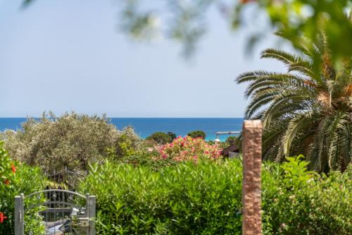 a view of the ocean from a garden at La Casa di Silvia in Costa Rei