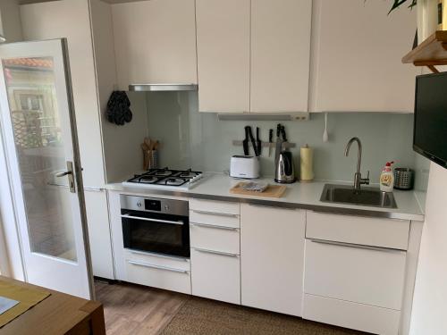 a kitchen with white cabinets and a sink and a stove at Anenska by Charles Bridge 2 in Prague