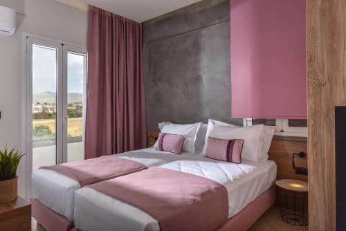um quarto com uma cama grande com paredes cor-de-rosa e uma janela em Villa Senses em Kato Gouves