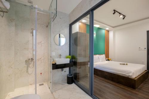 Un baño con cama y ducha de cristal. en LÁ HOTEL RIVERSIDE, en Ho Chi Minh