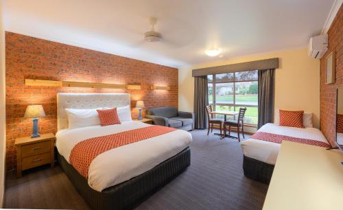 a hotel room with two beds and a desk at AAt 28 Goldsmith Motel in Hamilton