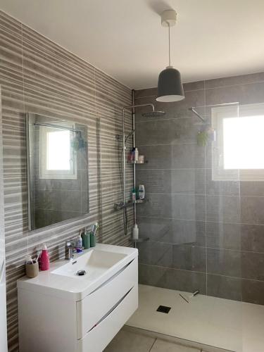 une salle de bain avec un lavabo et une douche dans l'établissement Magnifique villa individuelle climatisée 4 chambres avec piscine 11 m 5m, à Sérignan
