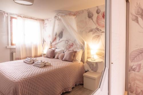 a bedroom with a bed with a pink flower wallpaper at La Pulcia B&B in Gradara