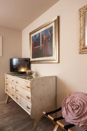 a living room with a dresser with a television and a chair at La Pulcia B&B in Gradara