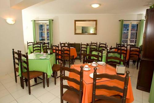 a dining room with tables and chairs and a mirror at Residencial Chafariz /Queimada in Funchal