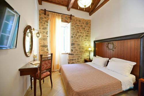 una camera con letto, scrivania e finestra di Hotel Sophia a Hydra