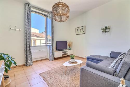 uma sala de estar com um sofá e uma televisão em LE REGORDANE - Appartement 4 personnes - Centre WiFi Cosy em Saint-Gilles