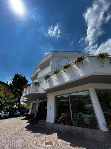 a white building with flowers in the windows at Hotel Oasi Wellness & Spa in Riva del Garda