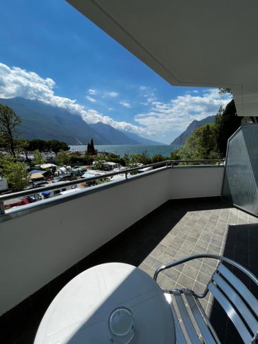 a balcony with a table and chairs and mountains at Hotel Oasi Wellness & Spa in Riva del Garda