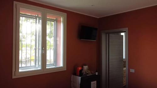 a room with two windows and a door to a bathroom at Sala dell Estate Guest House in Secchia