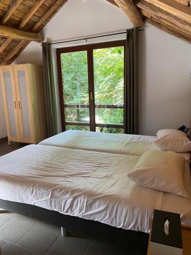 a bedroom with a large bed and a window at Parkhotel Villa des Effats Vielsalm in Vielsalm