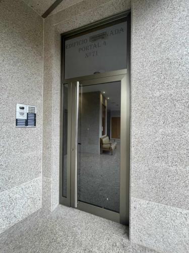 a glass door to a building with a sign on it at Grupo Gontad Ático Neaño in A Coruña