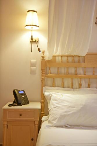 a bedroom with a bed with a phone on a night stand at Hotel Sophia in Hydra