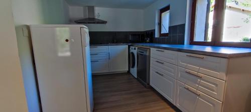 Una cocina con electrodomésticos blancos y un refrigerador blanco. en Le Petit Torrent, en Les Prats