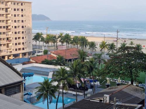uma vista para a praia a partir da varanda de um resort em Apartamento aconchegante a 100m da praia na Praia Grande