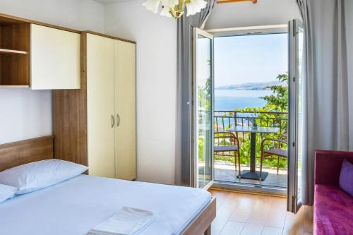 a bedroom with a bed and a balcony at Holiday Apartments Soparin in Senj