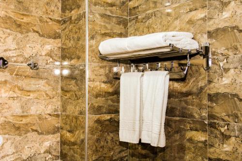a bathroom with white towels on a stone wall at Kristal Inn Hotel in Baku