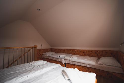 two beds in a attic room with white sheets at Apartmány Jurica Boží Dar 84 in Boží Dar