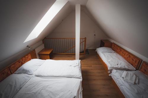 a attic room with two beds and a skylight at Apartmány Jurica Boží Dar 84 in Boží Dar