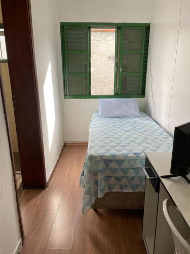 um pequeno quarto com uma cama e uma janela em Quartos Masculino - Romas House em Itu