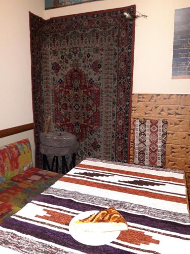 葉瑞文的住宿－阿姆旅館，卧室配有一张挂在墙上的地毯。