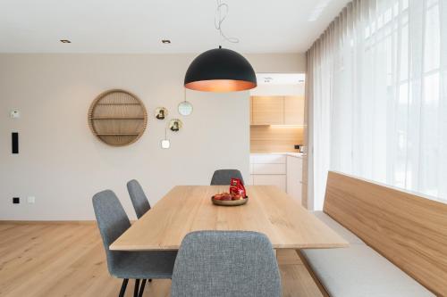 a dining room with a wooden table and chairs at VANEA - Alp Relax Guesthouse in Chienes