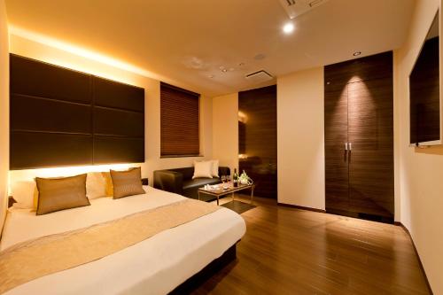 東京にあるHotel BIX Tokyo Gotandaのベッドとソファ付きのホテルルーム
