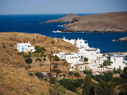 a group of white buildings on a hill next to the ocean at Villa Mariza Kythnos in Kithnos