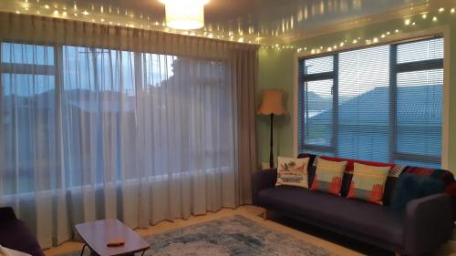 a living room with a couch and a large window at Beach Belle in Bowentown
