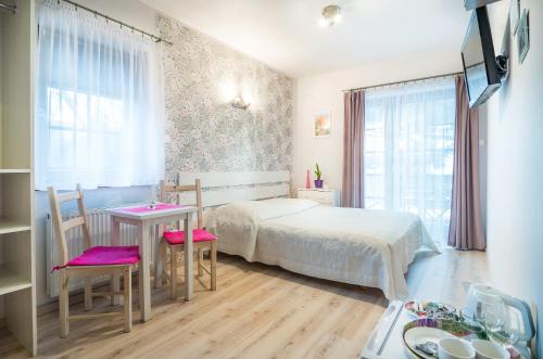 um quarto com uma cama, uma mesa e cadeiras em Willa 4 Pory Roku em Kazimierz Dolny