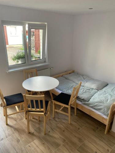 Zimmer mit einem Bett, einem Tisch und Stühlen in der Unterkunft Pokoje blisko morza in Sarbinowo
