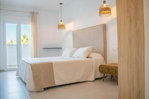 Schlafzimmer mit einem Bett mit weißer Bettwäsche und einem Fenster in der Unterkunft H Arena Mojacar in Mojácar