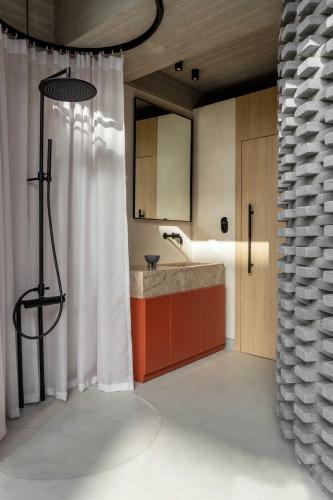 a bathroom with a sink and a shower with a shower curtain at The Newel Psychiko in Athens
