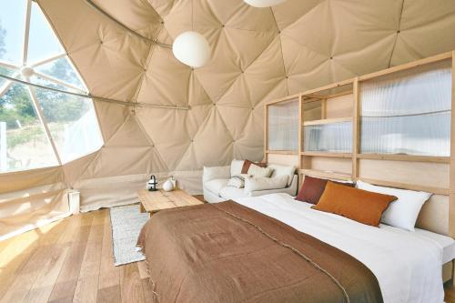 um quarto com uma cama grande num tecto abobadado em Dot Glamping 赤穂 em Ako