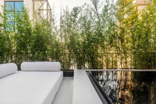 a garden with a white couch next to a pond at The Newel Psychiko in Athens