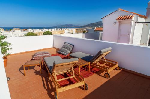 balcone con sedie e tavoli sul tetto di Tarifa Cozy House - Ocre et Vert - Maison de Plage a Tarifa